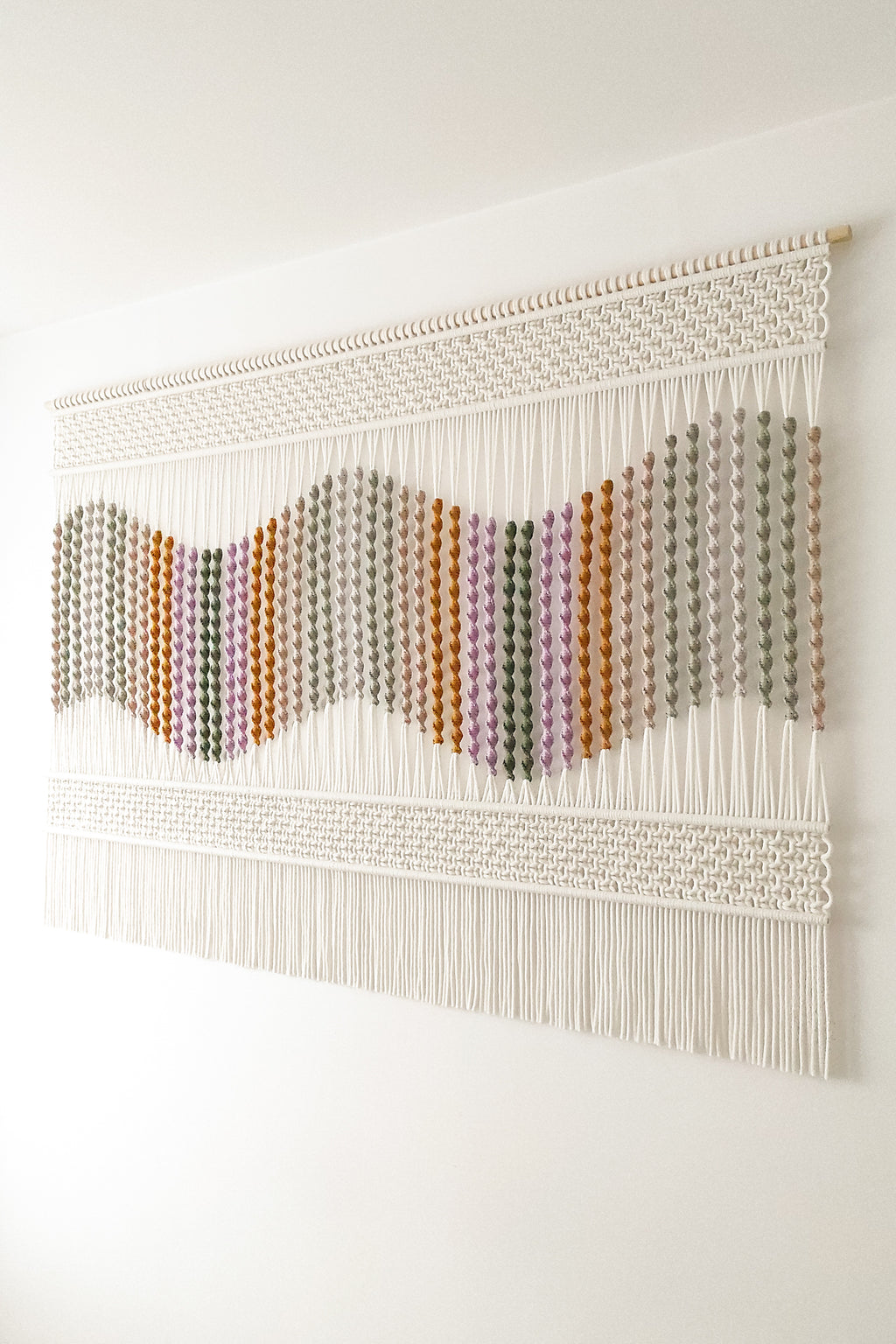 Boczne ujęcie kolorowej dekoracji ściennej SEASIDE DUNES podkreślające przestrzenną fakturę splotu i wielobarwny wzór.