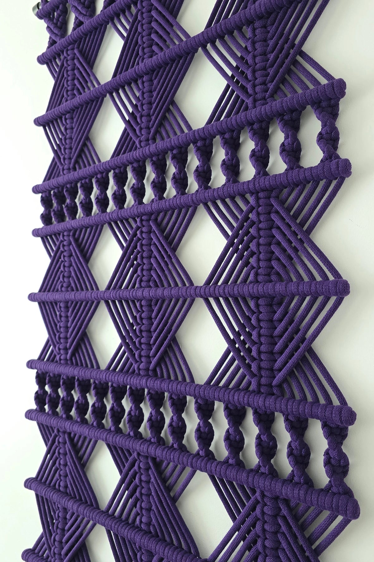 Detal geometrycznego wzoru i splotów ciemnofioletowej dekoracji ściennej VELVET NORDART